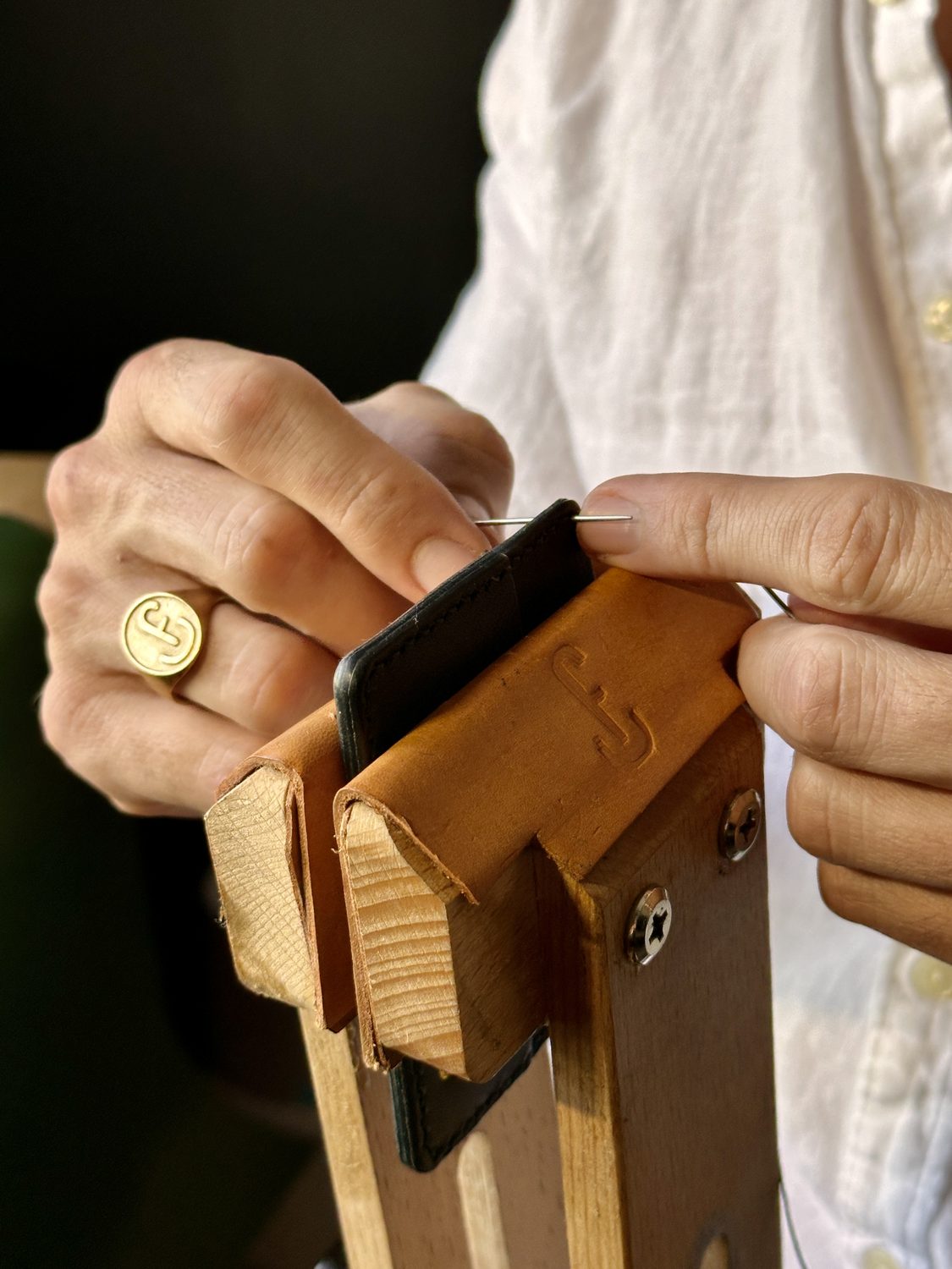 A wallet hand saddle-stitched in the stitching horse