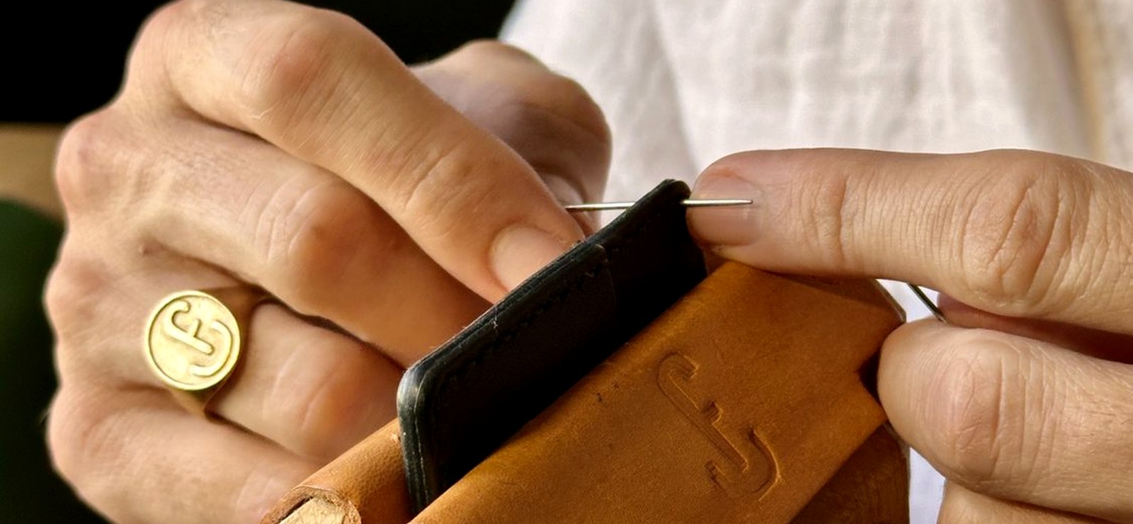 Two needles saddle-stitching leather by hand at the bench